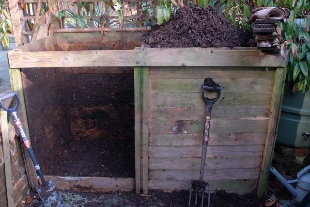 Wooden compost bin with removable front panels.