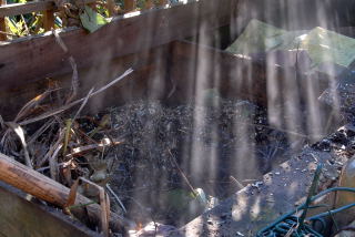 Steam rising from a recently filled compost heap.